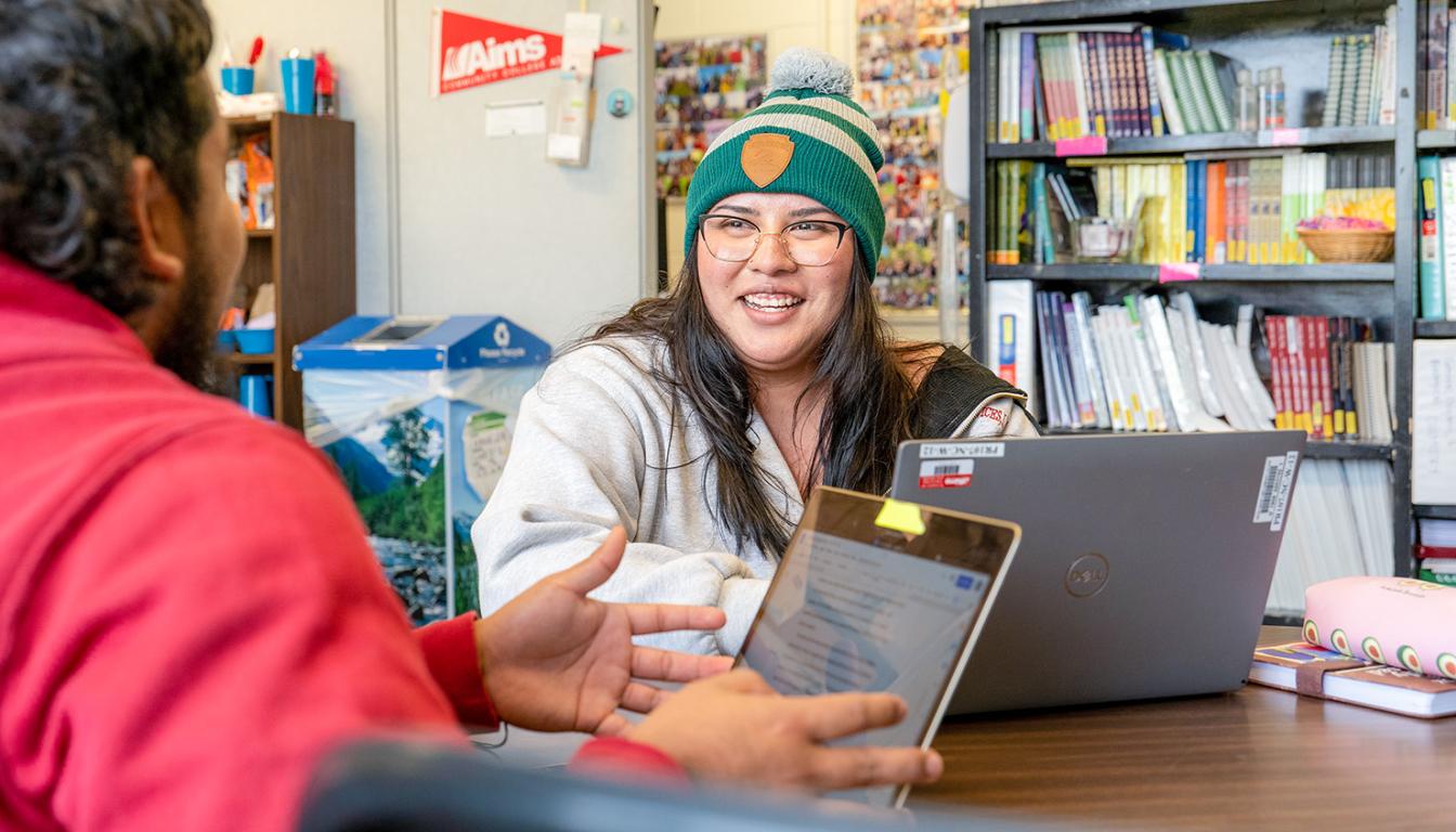 Two students chat during a class at Aims Community College