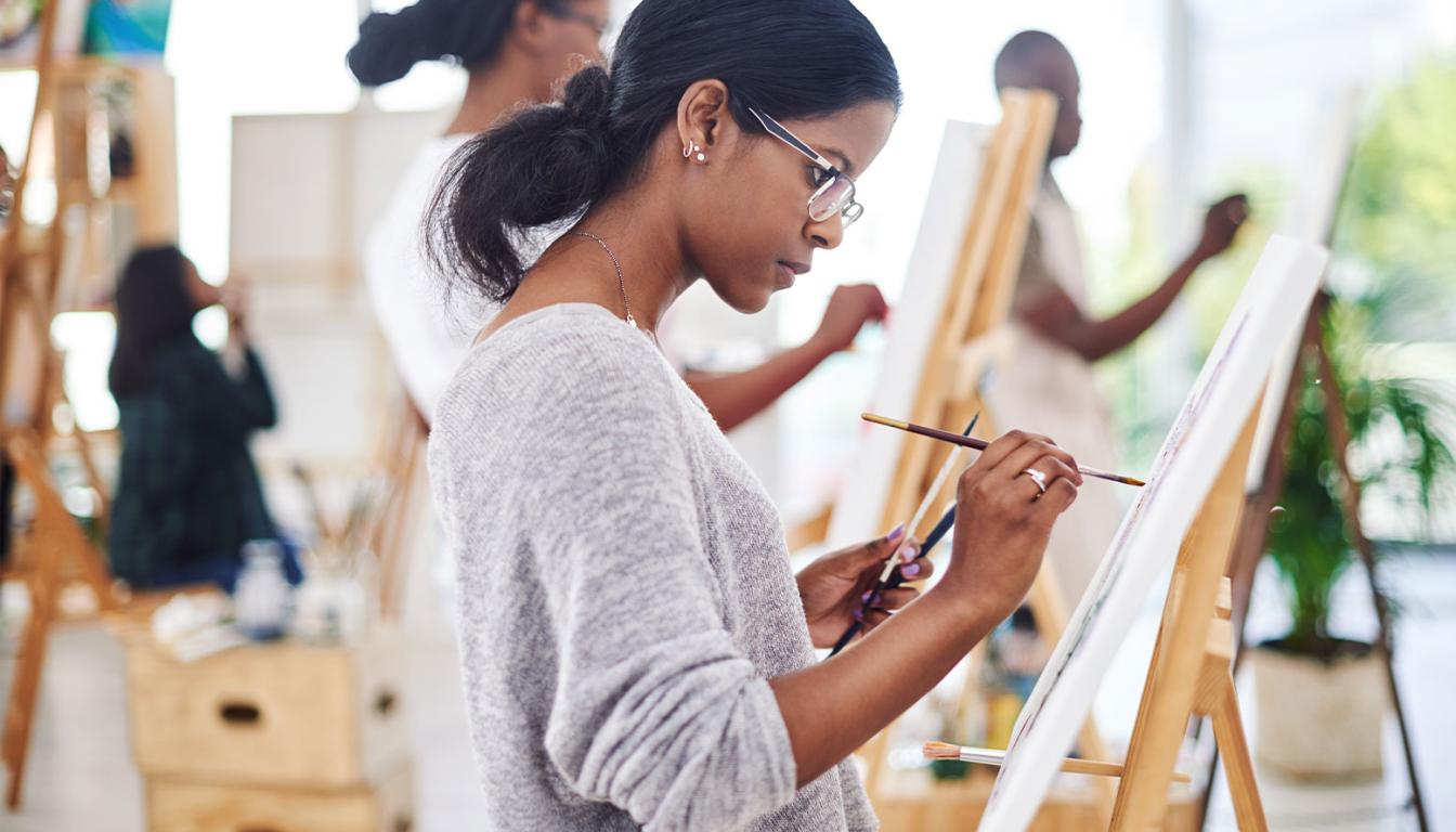 Liberal Arts student at Aims painting a canvas. 