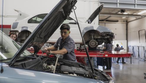 Student works under the hood of a car