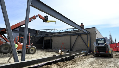 A crew works to put up steel beams for an expansion on the Thompson Career Campus