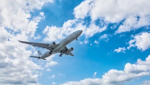 Airplane flying with blue sky with clouds