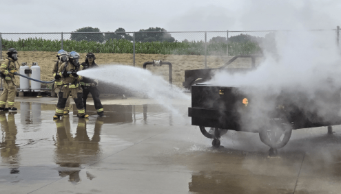 Students using fire hoses