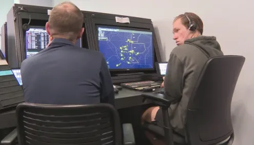 Student Aidan Rowe sits with an air traffic control instructor at Aims