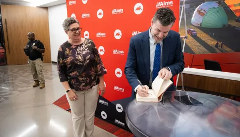 Speaker signs book for audience member