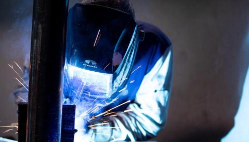 Student welding with helmet on