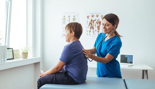 Doctor listening to student's heartbeat