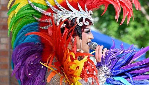 Person in Rainbow Feathers at a Pride Celebration