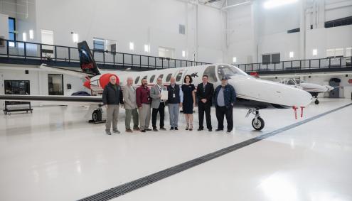 people standing in front of an airplane