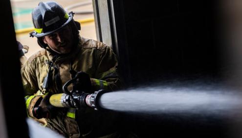 Firefighter student with a firehose