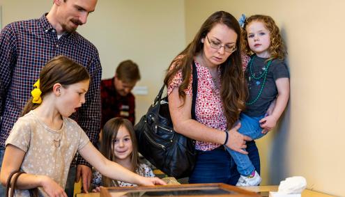 Mother and father and 3 kids looking at fossils