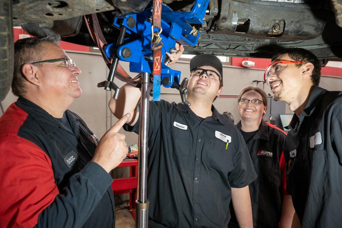 Aims Automotive Students and Instructors under a lifted vehicle