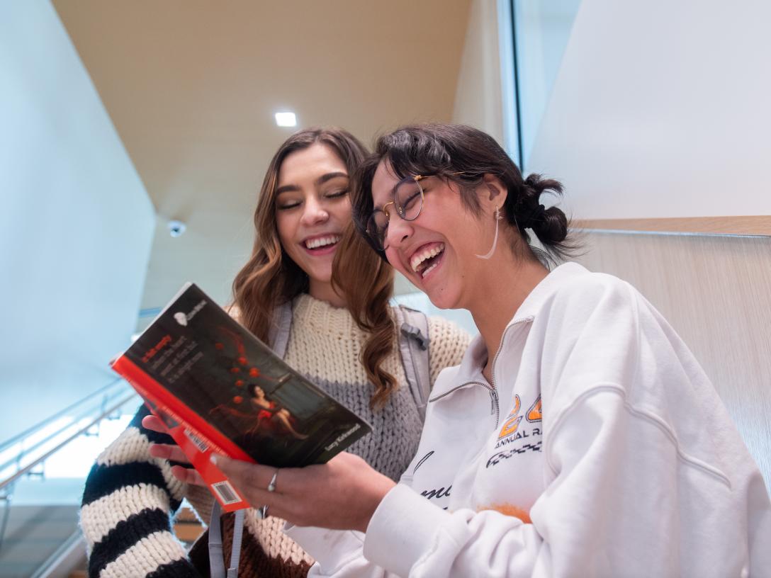 students on the stairs looking at a book