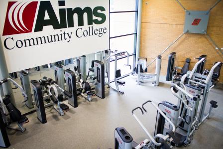 Photo of the inside of the PERC weight room. There are a variety of exercise machines.