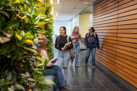 Aims students walking down the hall past the living wall on the Fort Lupton camp